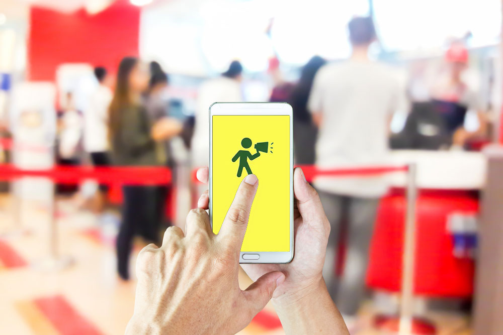 Man use mobile phone, blur image of people line up to buy fast food as background.