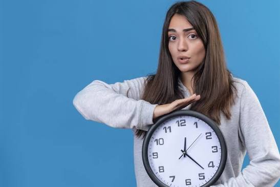 a girl holding a wall clock